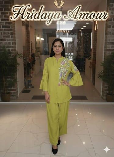 Model in a lime coord set with floral applique and flared sleeves